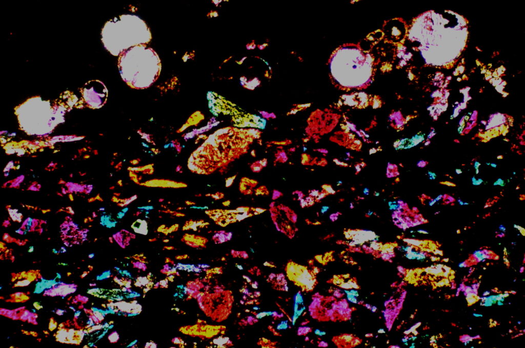 Organic rich shale with planktic foraminifera, quartz silt (blue), and authigenic feldspar crystals (UXN w/GP).